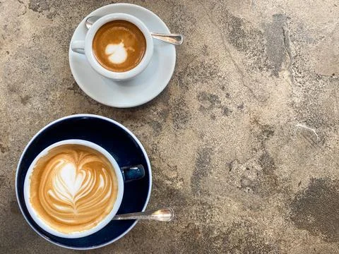 Two cups of fresh coffee with latte art on concrete table top view Stock Photos