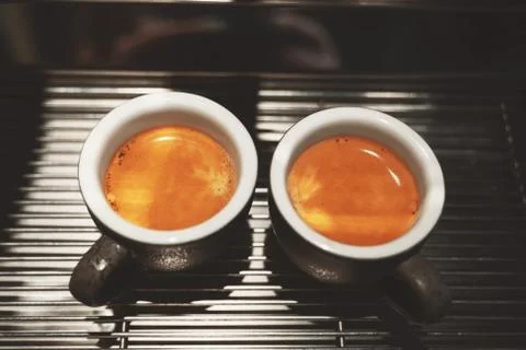 Two cups of fresh made hot coffee espresso americano standing on professional Stock Photos
