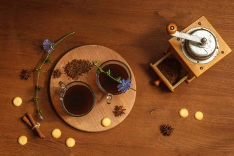 Two cups of ground chicory root coffee on a tray with cookies and cinnamon Stock Photos