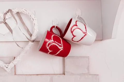 Two cups with hearts in the kitchen and a wooden white heart. Valentine's D.. Stock Photos
