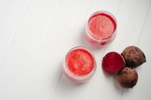 Two cups of hot beet coffee latte on a white wooden background. A trendy 库存照片