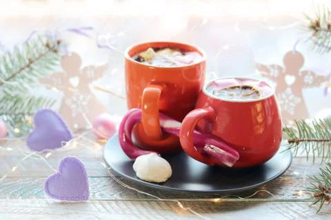 Two cups with a hot drink, marshmallows, caramel sticks, Christmas decor, hearts Stock Photos