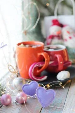 Two cups with a hot drink, marshmallows, caramel sticks, Christmas decor, hearts Stock Photos