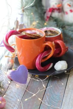 Two cups with a hot drink, marshmallows, caramel sticks, Christmas decor, hearts Stock Photos
