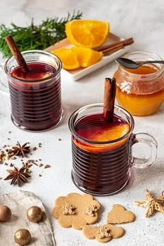 Two cups of hot mulled wine on a grey background, with spices and ginger cookies Stock Photos