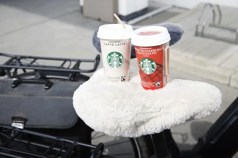Two cups of iced coffee latte and hazelnut macchiato with Starbucks logo stand Stock Photos