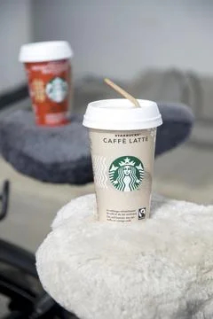 Two cups of iced coffee latte and hazelnut macchiato with Starbucks logo stand Stock Photos