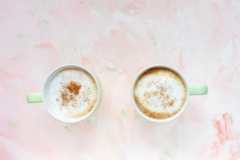 Two cups of latte coffee on light pink background Foto stock