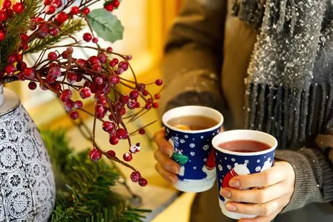 Two cups of mulled wine in womans hands outside. Mulled wine with slice of Stock Photos