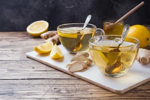 Two cups of natural herbal tea ginger lemon and honey on a wooden backgroun.. Stock Photos