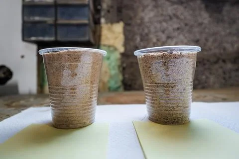 Two Cups of Soil Samples on Workbench in Indoor Workshop Setting 스톡 사진