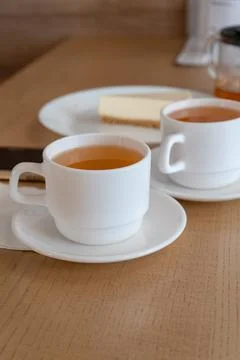 Two cups of tea and cake cheesecake in cafe daylight lunch lunch snack vertical Foto stock