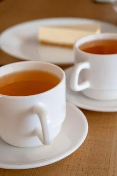 Two cups of tea and cake cheesecake in cafe daylight lunch lunch snack vertical Foto stock