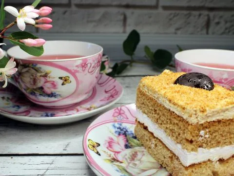 Two cups of tea and a close-up cake on a wooden table Stock Photos
