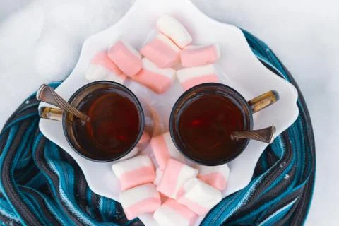 Two cups of tea with marshmallows under the tree in winter in the snow Stock Photos