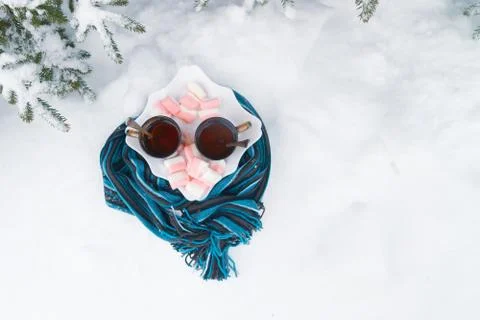 Two cups of tea with marshmallows under the tree in winter in the snow Stock Photos