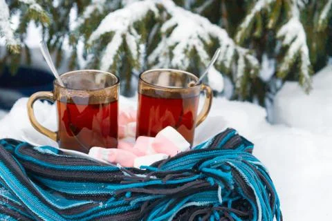 Two cups of tea with marshmallows under the tree in winter in the snow Stock Photos