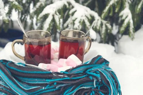 Two cups of tea with marshmallows under the tree in winter in the snow Stock Photos