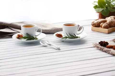Two cups of tea with spices on white table Stock Photos