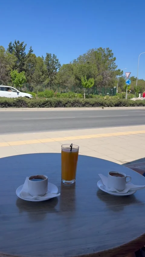 Two cups of traditional cyprus coffee and orange juice on table near the street Stock Footage 336219059