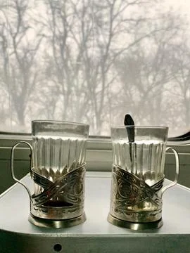 Two cups in a train on a table. Faceted glasses for tea on the train. Dishes  Stock Photos