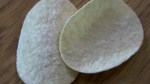 Two Curved Potato Crisps Rotating in Geometric Arrangement Stock Footage 345426714