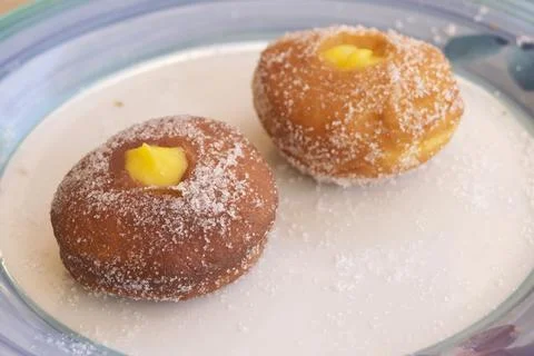 Two custard filled doughnuts with sugar coating on a plate Stock Photos