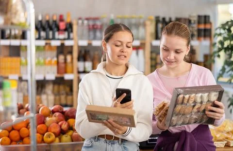Two customers scan the barcode of candy packages Photos