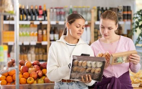 Two customers scan the barcode of candy packages Photos
