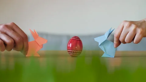 Two cute and funny paper Easter bunnies meeting at a red decorated Easter egg. Stock Footage 149068378