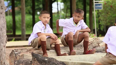 Two Cute Asian Grade School Students Sitting On A Log 스톡 동영상 34546983