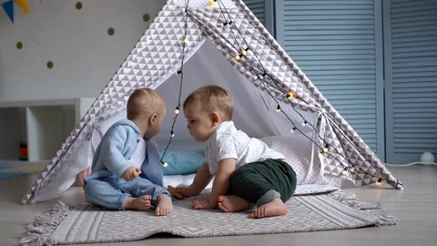 Two cute babies staged a halt near the children's tent and eat cookies Stock Footage 103661481