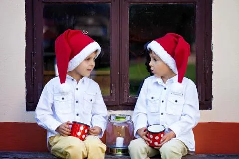 Two cute boys, sitting on a window shield, waiting for Santa Stock Photos