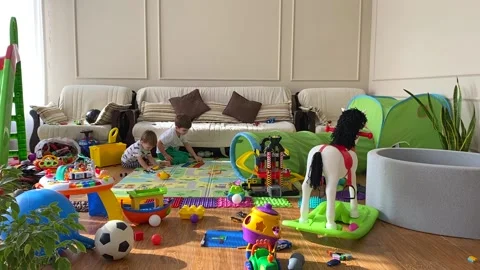 Two cute children are playing with toys in the children's room. A mess in the Stock Footage 171381054