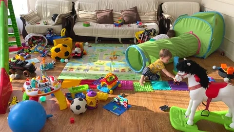 Two cute children are playing with toys in the children's room. A mess in the Vidéo 171381106