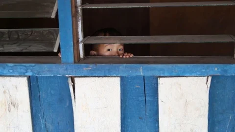 Two cute childrens peeping through the window, Malaysia Stock Footage 95355201