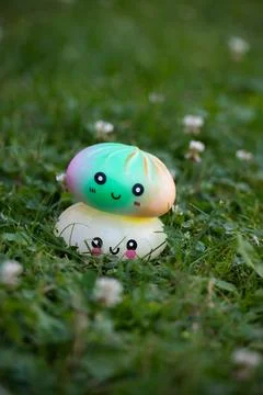 Two cute dumpling squishies with kawaii faces on the grass Stock Photos