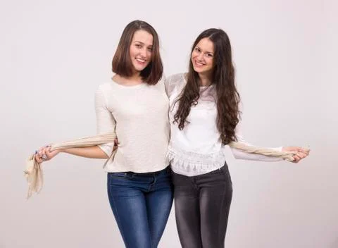 Two cute friends hugging in studio. Front view Stock Photos