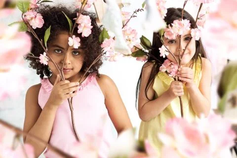 Two cute grils hiding herself behind branches Stock Photos