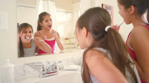 Two cute little sisters brush their teeth together as they get ready for bed Stock Footage 34011119