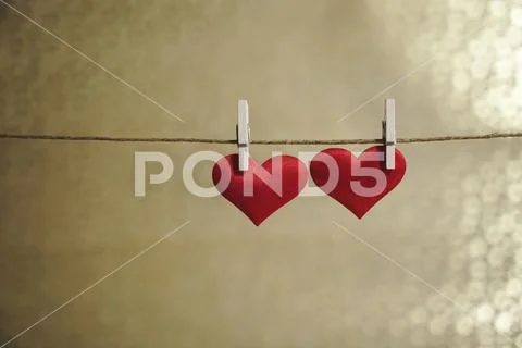 Two cute red hearts hanging side by side from a string by clothes peg. Valentine Stock Photos