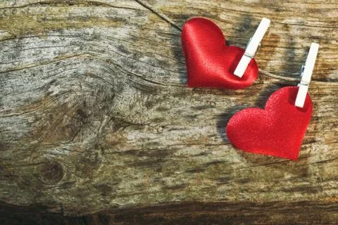 Two cute red hearts on string with clothes pegs on wooden background. Romantic Stock Photos