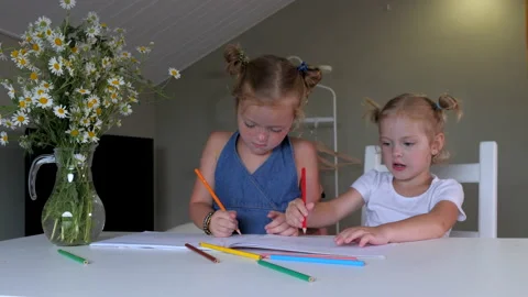 Two cute sisters are drawing in an album with colored pencils at home. Stock Footage 145902282