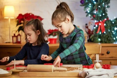 Two cute sisters make and decorate Christmas gingerbread cookies Stock Photos