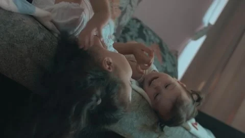 Two cute sisters playing on sofa. Having fun time at home. Stock Footage 251730548