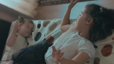 Two cute sisters playing on sofa. Peekaboo game. Having fun time at home. Stock Footage 251730850