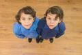 The two cute twin look to the camera. View from above Photo