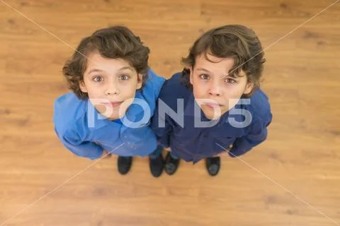 The two cute twin look to the camera. View from above Stock Photos