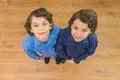 The two cute twin look to the camera. View from above Photo