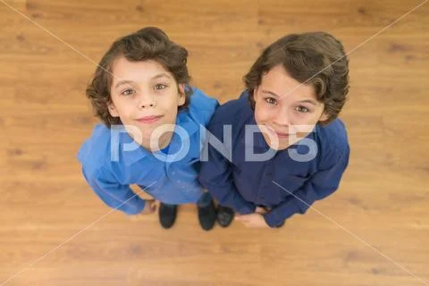 The two cute twin look to the camera. View from above Stock Photos